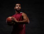 retrato-deportista-afroamericano-jugador-baloncesto-ropa-deportiva-pelota-sobre-fondo-oscuro (1)
